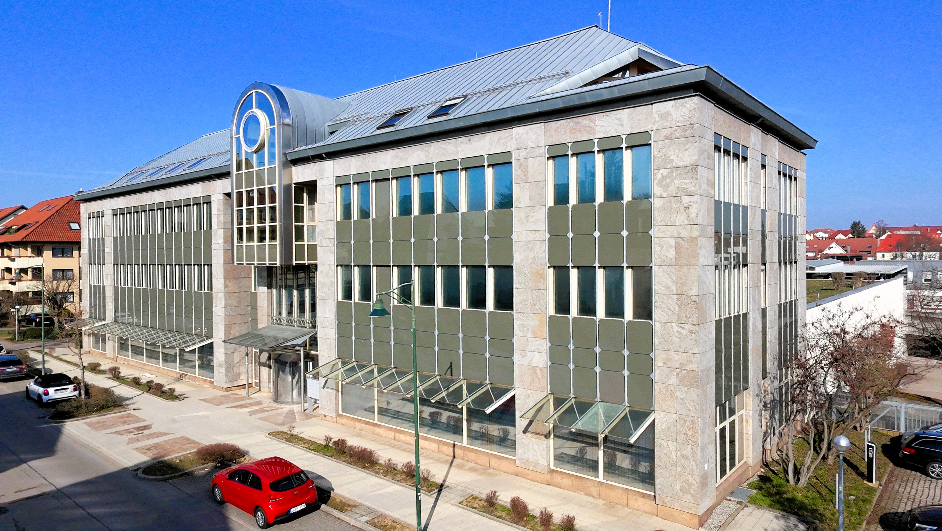 Außenansicht des Bürokomplexes Hoferstraße 30 mit markanter Glasfront und Natursteinfassade